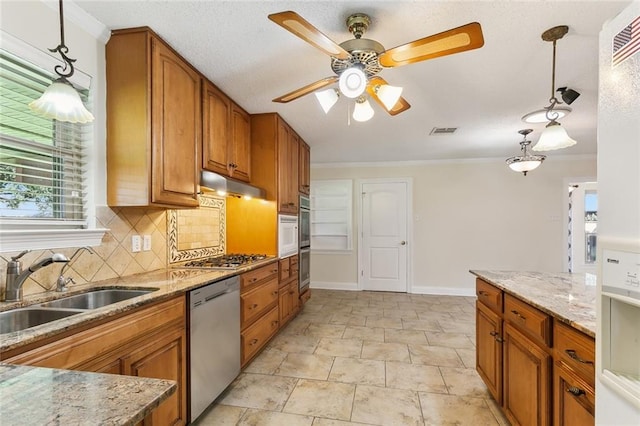 kitchen featuring decorative light fixtures, sink, ornamental molding, tasteful backsplash, and appliances with stainless steel finishes