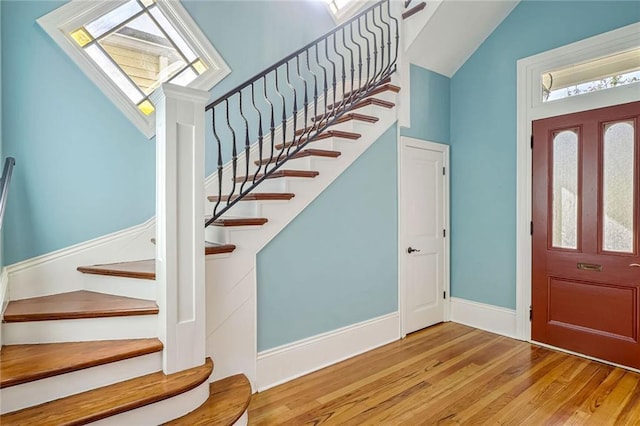 entryway with light wood-type flooring and vaulted ceiling