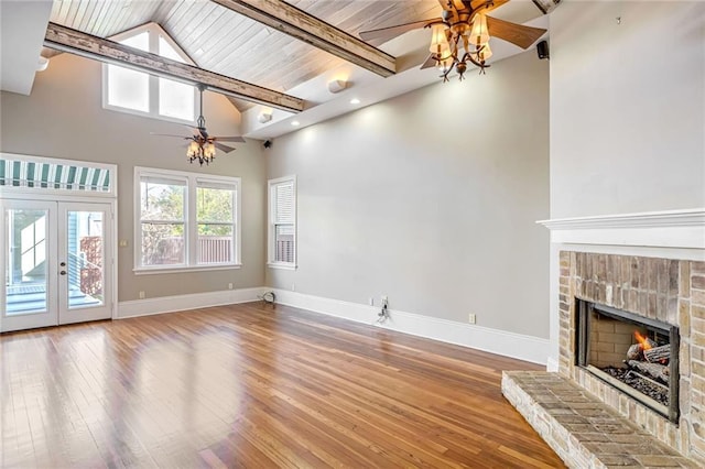 unfurnished living room with a fireplace, ceiling fan, french doors, and hardwood / wood-style floors