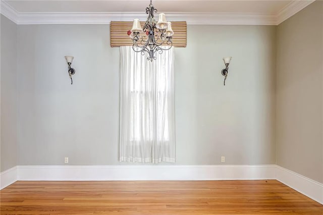 unfurnished dining area with ornamental molding, hardwood / wood-style flooring, and an inviting chandelier