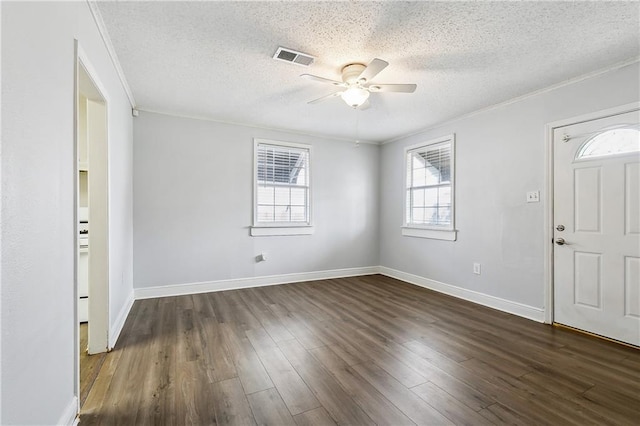 entryway with dark wood-type flooring, crown molding, and a textured ceiling