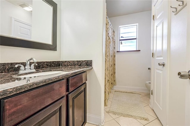 bathroom with vanity, tile patterned flooring, and toilet