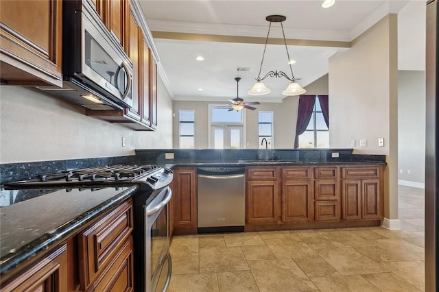 kitchen featuring dark stone countertops, sink, decorative light fixtures, stainless steel appliances, and ornamental molding