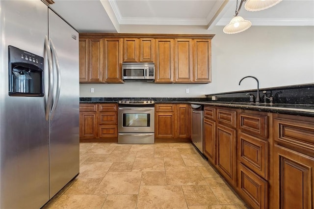 kitchen featuring appliances with stainless steel finishes, sink, pendant lighting, dark stone counters, and ornamental molding