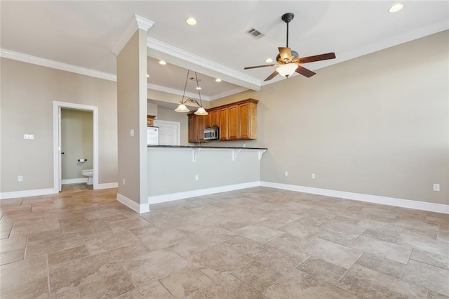 kitchen featuring kitchen peninsula, ornamental molding, ceiling fan, a kitchen bar, and pendant lighting