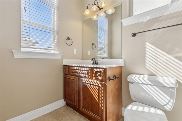 bathroom with toilet, vanity, and tile patterned flooring