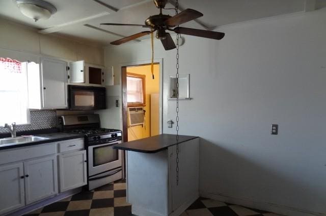 kitchen with ceiling fan, decorative backsplash, gas stove, sink, and kitchen peninsula