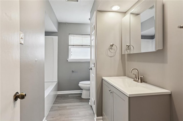 bathroom with hardwood / wood-style flooring, vanity, and toilet