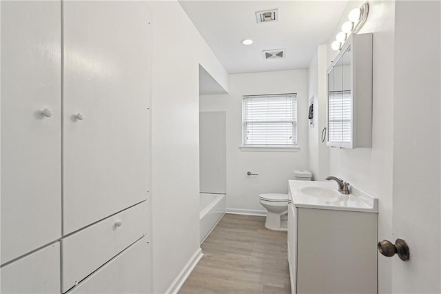 bathroom featuring toilet, vanity, and hardwood / wood-style floors