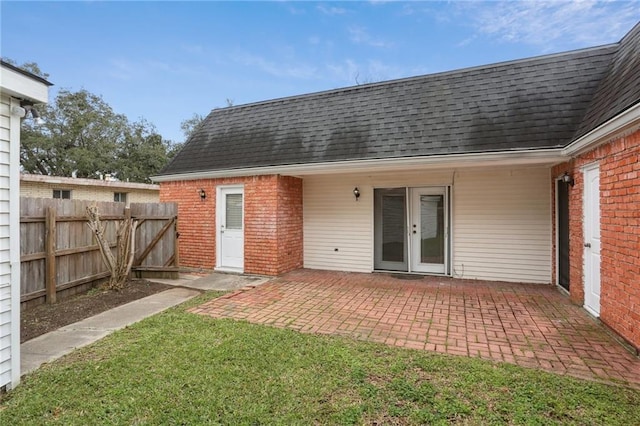 back of property with a patio area and a lawn