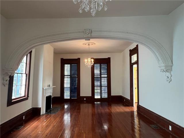 1608 Governor Nicholls St, New Orleans, LA 70116 - interior space featuring arched walkways, a notable chandelier, hardwood / wood-style flooring, and plenty of natural light