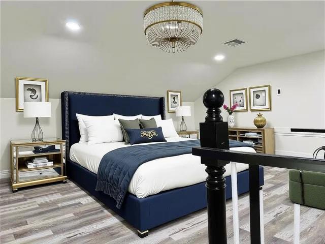 1608 Governor Nicholls St, New Orleans, LA 70116 - bedroom featuring visible vents, vaulted ceiling, an inviting chandelier, and wood finished floors