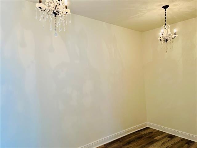 1608 Governor Nicholls St, New Orleans, LA 70116 - unfurnished dining area with dark wood-type flooring, a notable chandelier, and baseboards