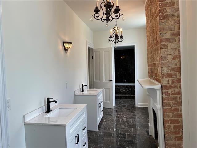 1608 Governor Nicholls St, New Orleans, LA 70116 - bathroom featuring a sink, two vanities, marble finish floor, and an inviting chandelier