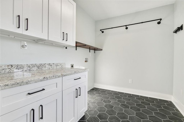 clothes washing area featuring cabinet space, baseboards, washer hookup, and hookup for an electric dryer