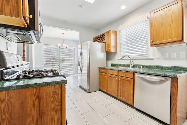 kitchen with appliances with stainless steel finishes, plenty of natural light, brown cabinetry, and a sink