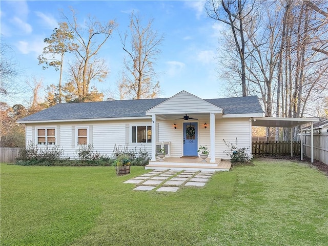 view of front facade with ceiling fan, a front lawn, and a carport