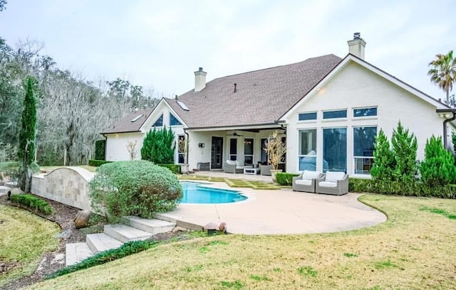 back of property featuring a patio, a chimney, outdoor lounge area, a lawn, and ceiling fan