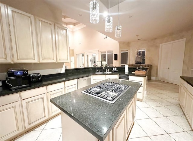 kitchen featuring kitchen peninsula, stainless steel gas cooktop, a center island, sink, and pendant lighting