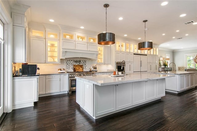 501 Emerald St, New Orleans, LA 70124 - kitchen with high quality appliances, visible vents, dark wood finished floors, a large island with sink, and ornamental molding