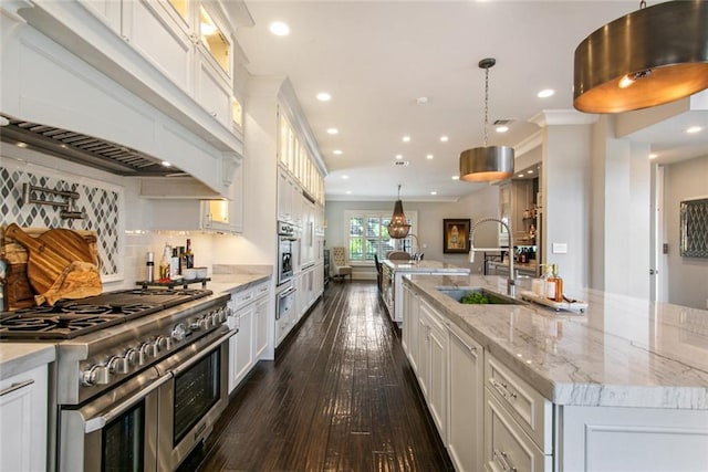 501 Emerald St, New Orleans, LA 70124 - kitchen featuring a large island, appliances with stainless steel finishes, a sink, dark wood-style floors, and glass insert cabinets