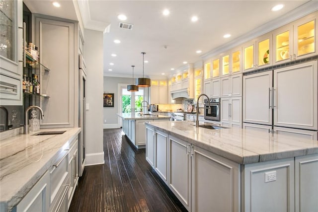 501 Emerald St, New Orleans, LA 70124 - kitchen featuring dark wood-style flooring, a spacious island, ornamental molding, and a sink