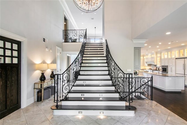 501 Emerald St, New Orleans, LA 70124 - stairway with crown molding, a notable chandelier, a wealth of natural light, and a towering ceiling