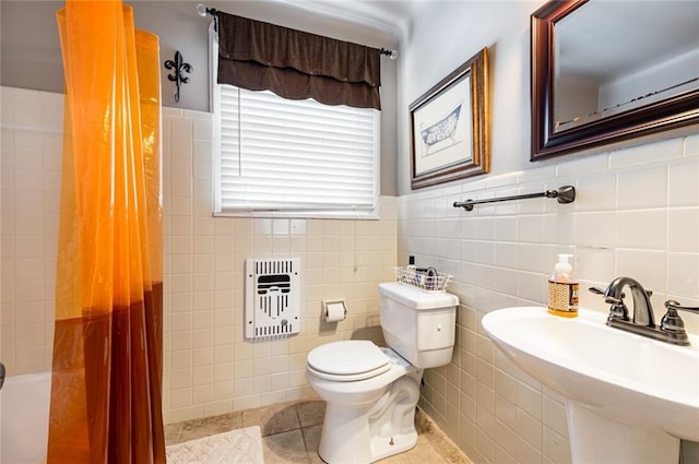 full bathroom featuring shower / bath combo with shower curtain, sink, tile patterned flooring, toilet, and heating unit