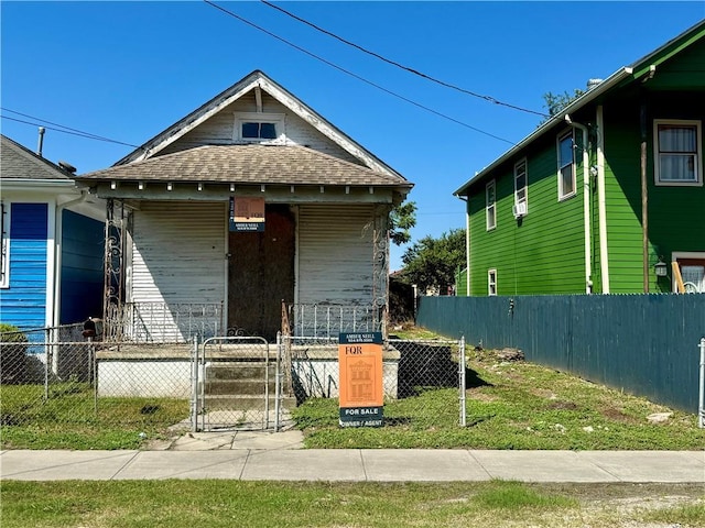 view of front of property featuring a fenced front yard, a porch, and a gate