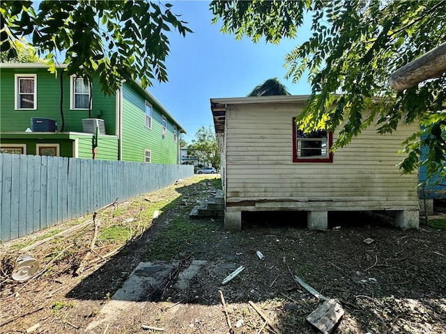 view of home's exterior featuring cooling unit and fence