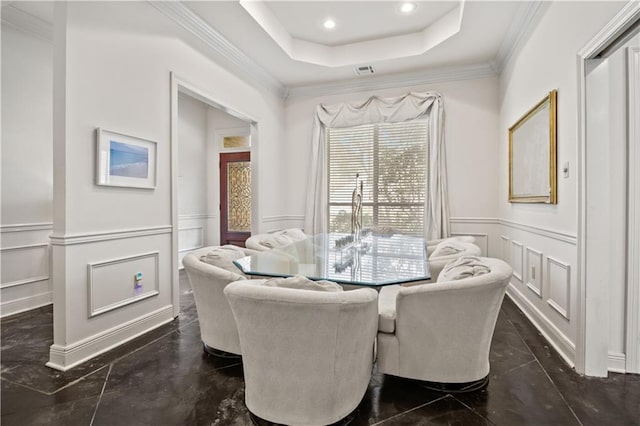 dining space featuring a tray ceiling and ornamental molding