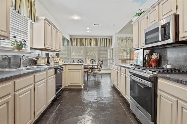 2021 W Ridge Dr, Mandeville, LA 70448 - kitchen featuring appliances with stainless steel finishes, a sink, backsplash, cream cabinetry, and dark countertops