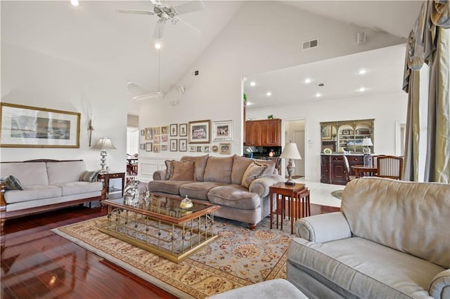 living room with ceiling fan, high vaulted ceiling, and wood-type flooring