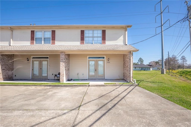 view of front of property with french doors and a front lawn