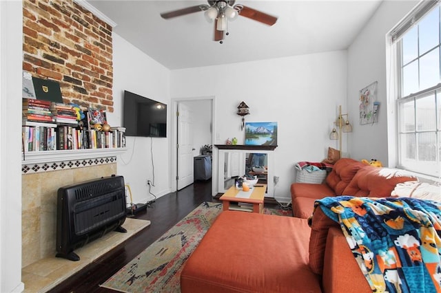 living room featuring heating unit, ceiling fan, and dark hardwood / wood-style flooring