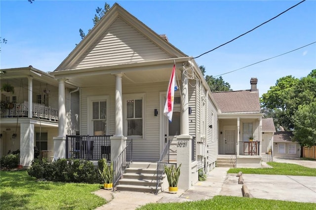 bungalow featuring covered porch and a front yard