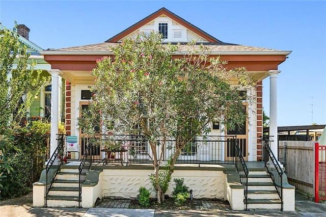 view of front facade featuring a porch and fence