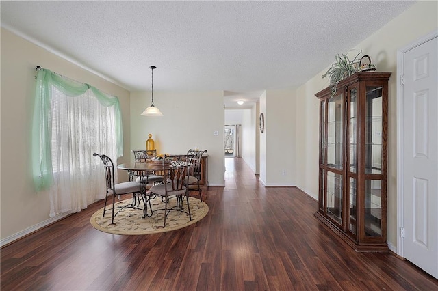 dining space featuring a textured ceiling and dark hardwood / wood-style floors