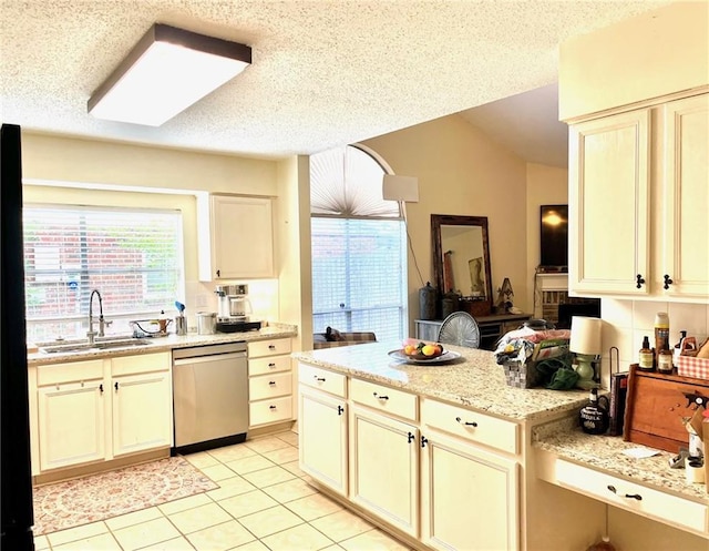 kitchen featuring stainless steel dishwasher, a sink, light tile patterned floors, a textured ceiling, and light stone countertops