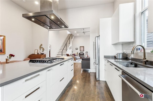 kitchen with white cabinets, island range hood, sink, and appliances with stainless steel finishes