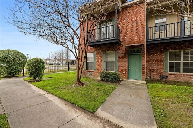 exterior space with a front yard and a balcony