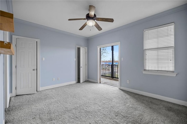 carpeted spare room featuring ceiling fan and ornamental molding