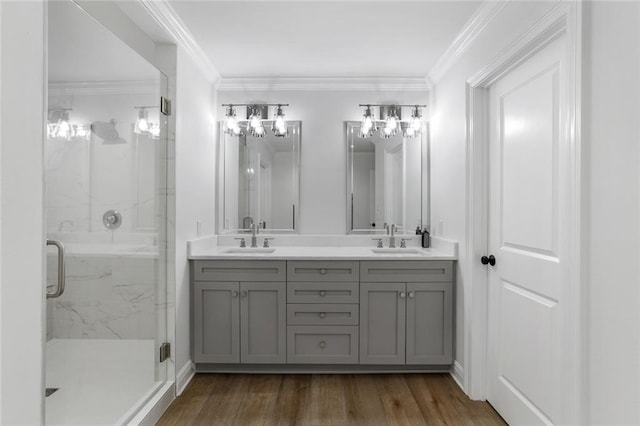 bathroom featuring crown molding, vanity, a shower with shower door, and wood-type flooring