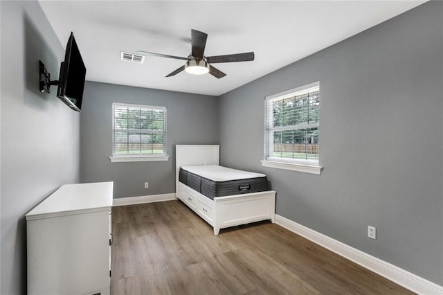 unfurnished bedroom featuring multiple windows, light hardwood / wood-style flooring, and ceiling fan