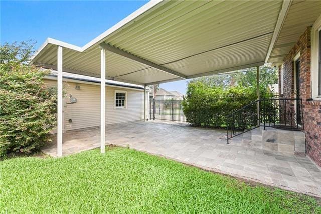 view of patio / terrace featuring fence and a carport