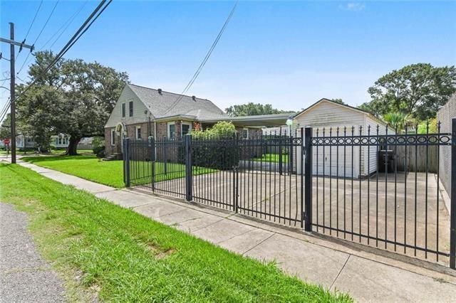 view of gate with a fenced front yard and a lawn