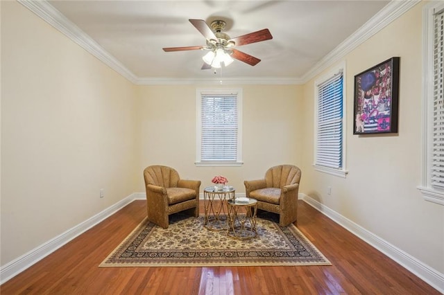 sitting room featuring crown molding, baseboards, and wood finished floors