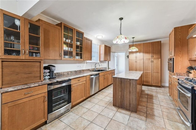 kitchen featuring brown cabinetry, wine cooler, appliances with stainless steel finishes, a center island, and a sink