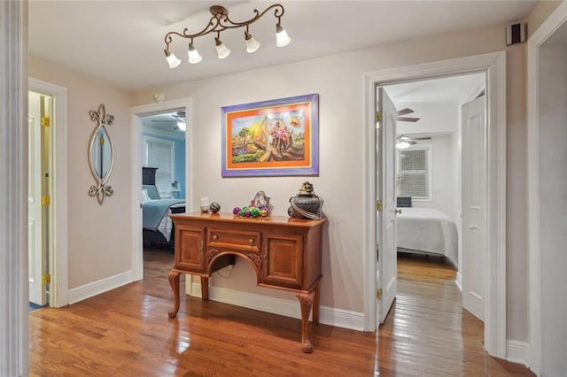 hall with baseboards and wood finished floors