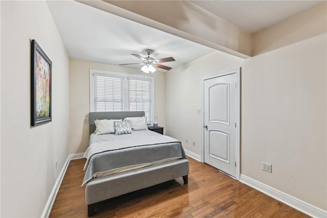 bedroom featuring ceiling fan, wood finished floors, and baseboards